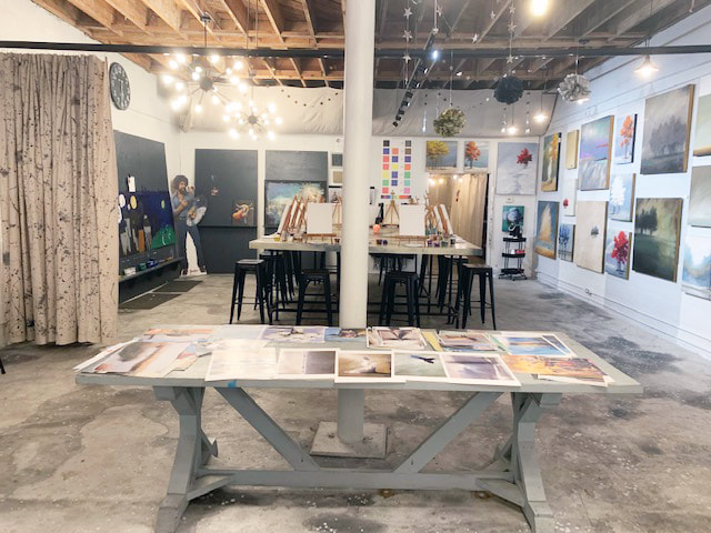 Adults painting on canvases at a hamburger-heaven paint party