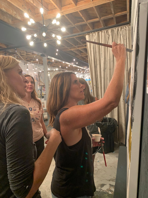 Participants smiling with finished canvases