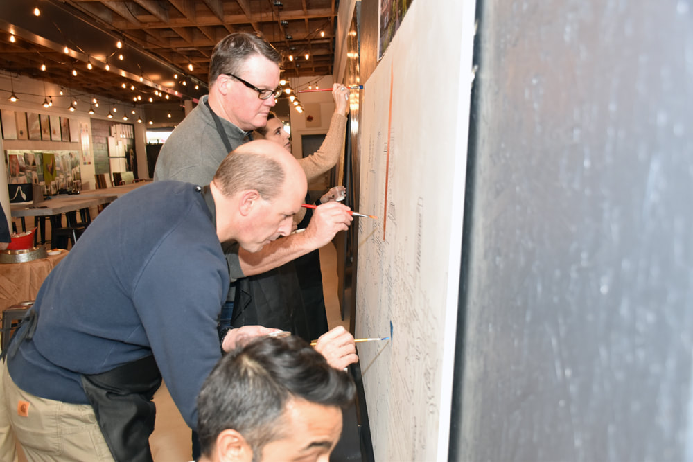 Group painting their team mural together at the studio