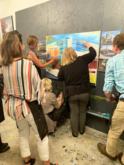 Group painting around a tabletop canvas