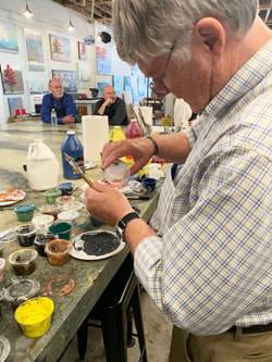 Person concentrating on a detail on the group mural