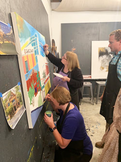 Group celebrating with their finished collaborative canvas