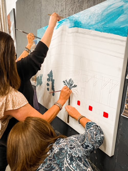 Mural team-building participants with brushes and palette