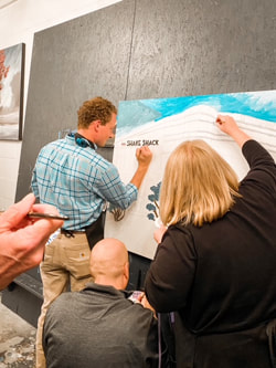 Group standing in front of their nearly-finished mural